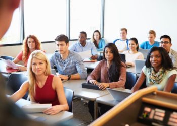 A group of people sitting in a room Description automatically generated with low confidence