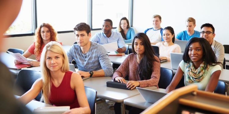 A group of people sitting in a room Description automatically generated with low confidence